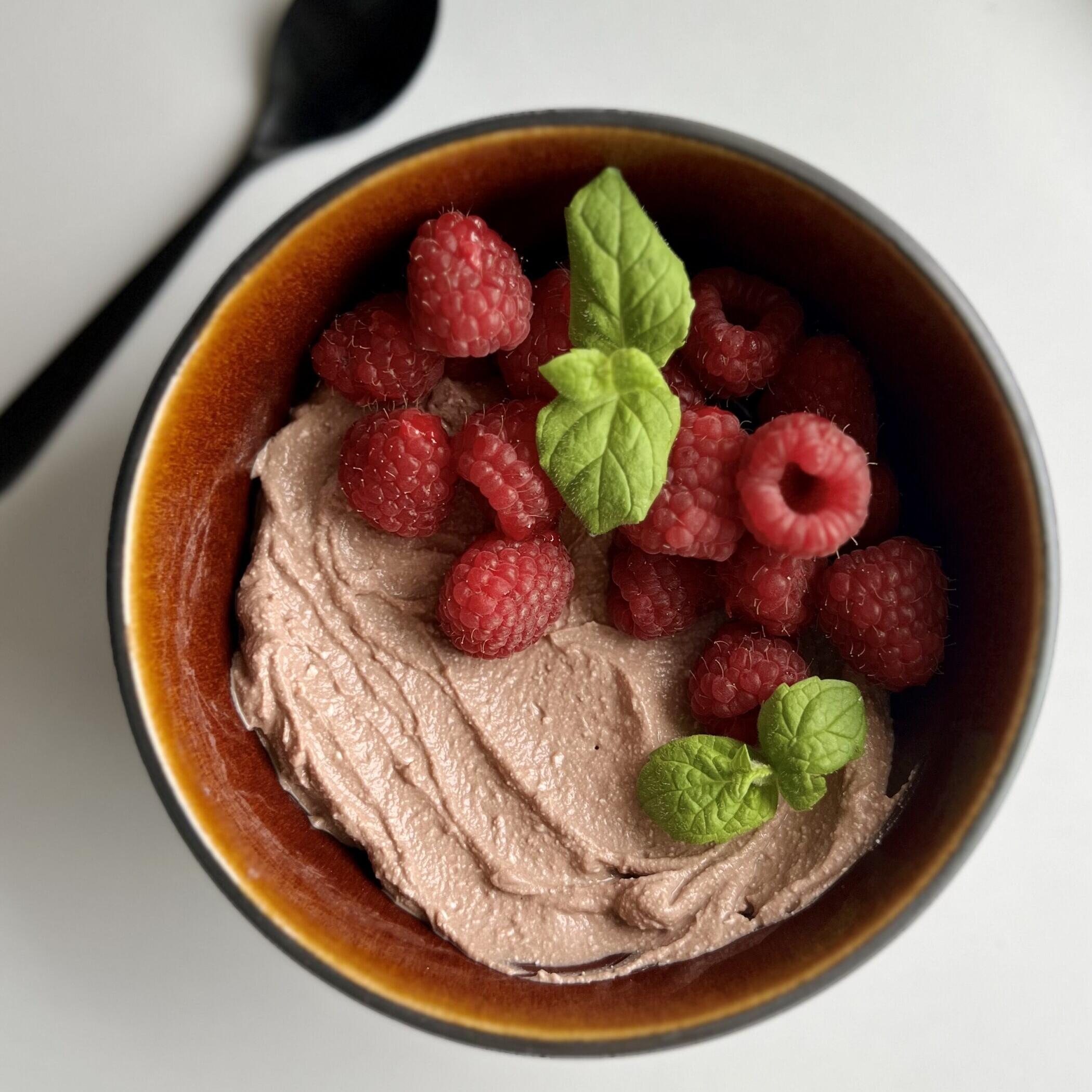 Sjokoladekrem av cottage cheese, toppet med bringebær