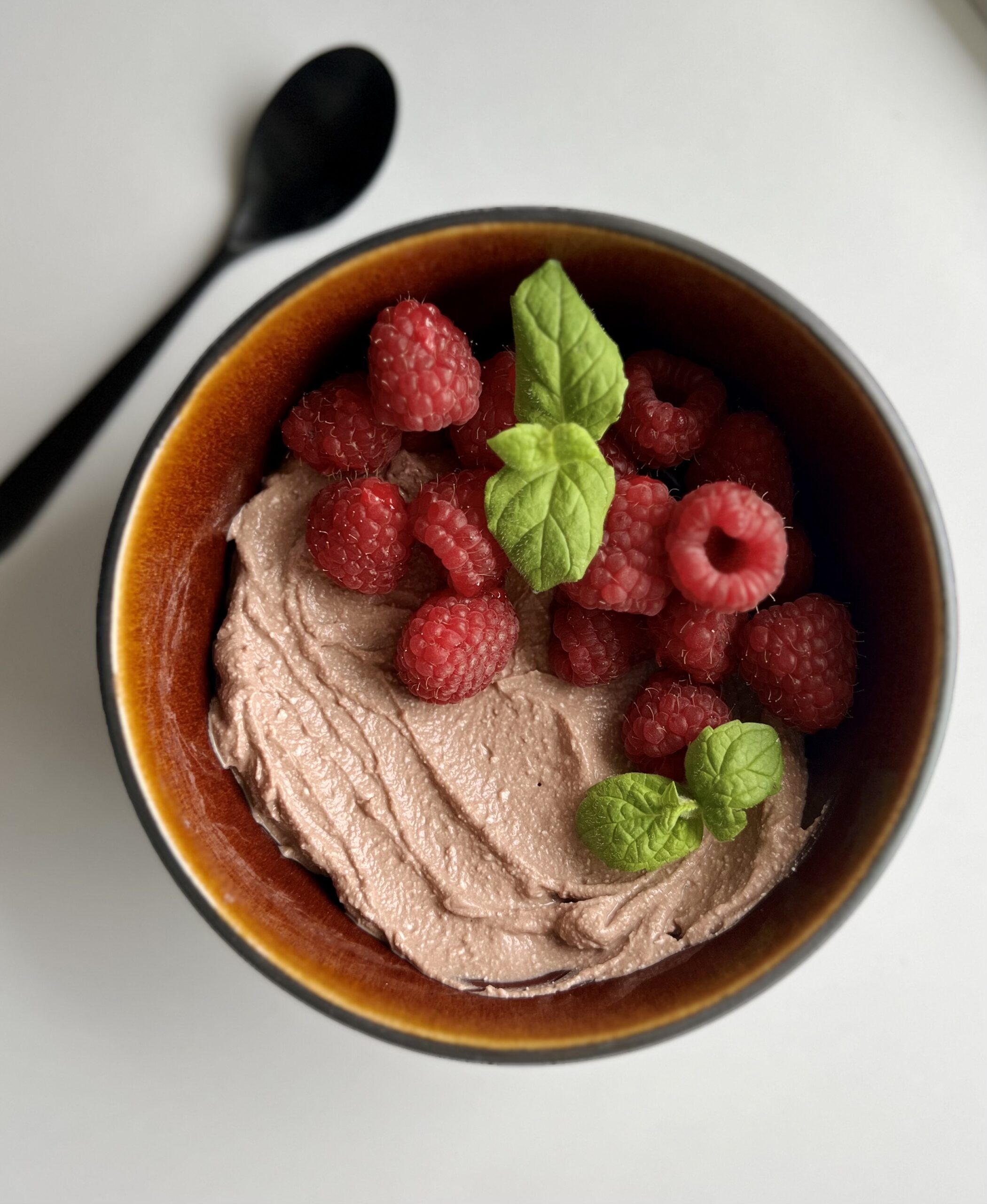 Sjokoladekrem av cottage cheese, toppet med bringebær